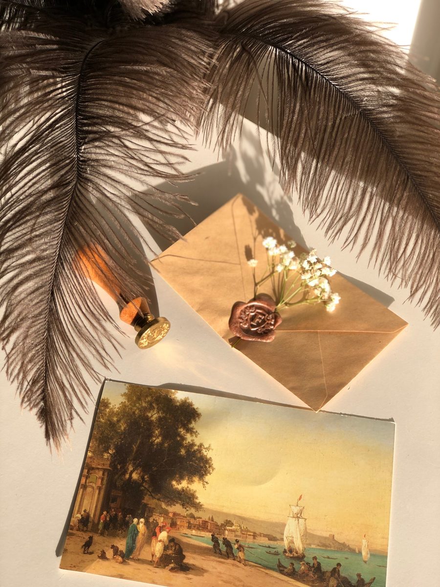 A sealed envelope with dried flowers and a feather